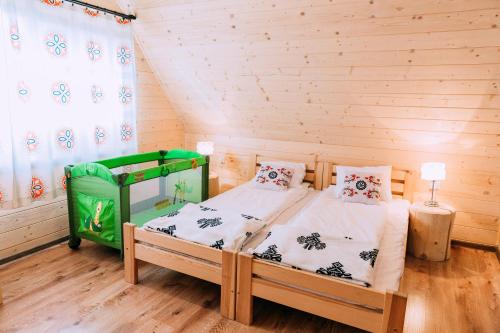 a bedroom with a bed in a wooden room at Czarna Owca in Kościelisko
