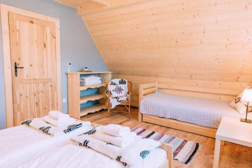 a bedroom with two beds and a desk and a chair at Czarna Owca in Kościelisko