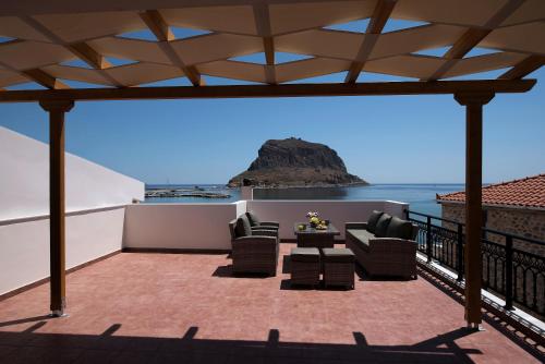 a patio with chairs and a table on a balcony at Cyrenia Guesthouse in Monemvasia