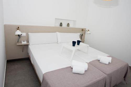 biała sypialnia z łóżkiem z 2 poduszkami w obiekcie MONKÓ - MANGO & TROPYCAL APARTMENT o w mieście Torremolinos