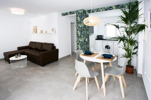 salon ze stołem, krzesłami i kanapą w obiekcie MONKÓ - MANGO & TROPYCAL APARTMENT o w mieście Torremolinos