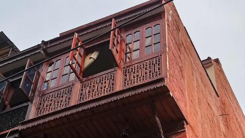 a balcony on a building with a window at Pottery Home in Bhaktapur