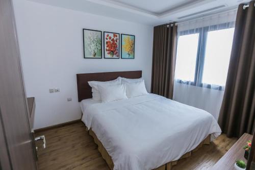 a bedroom with a white bed and a window at HNC Premier Hotel & Residences in Hanoi