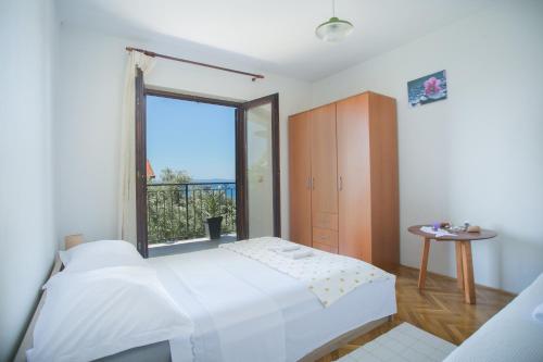 a bedroom with a bed and a large window at House Silva in Podstrana