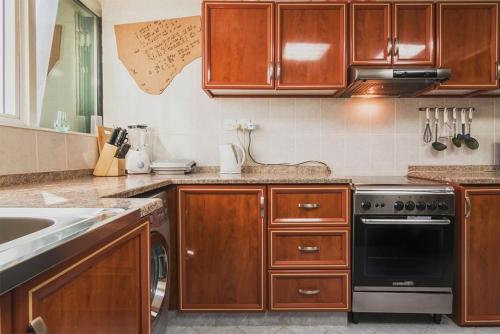 a kitchen with wooden cabinets and a dishwasher at Exclusive Creek Bay Apartment in Ajman