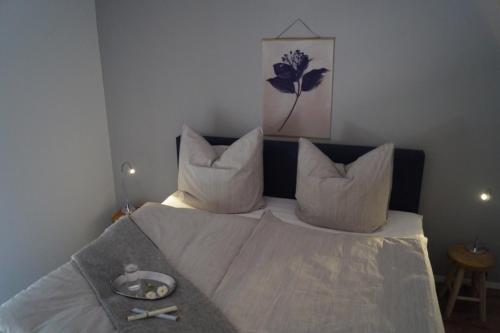 a bed with white sheets and pillows in a bedroom at Liebevoll eingerichtete Ferienwohnung am Rande von Berlin in Blankenfelde