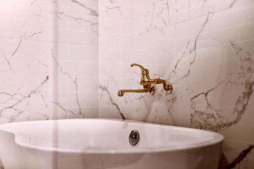 a bathroom with a sink and a gold faucet at THE ROOT2 HOTEL in Kyoto