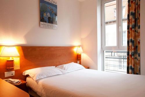 a hotel room with two beds and a window at Hotel Le 21ème in Strasbourg