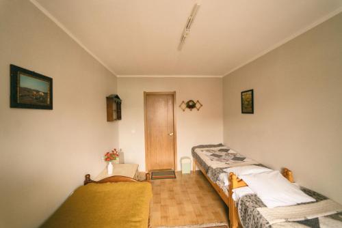 Habitación con 2 camas y puerta en Town Yard Hostel, en Ulán Bator