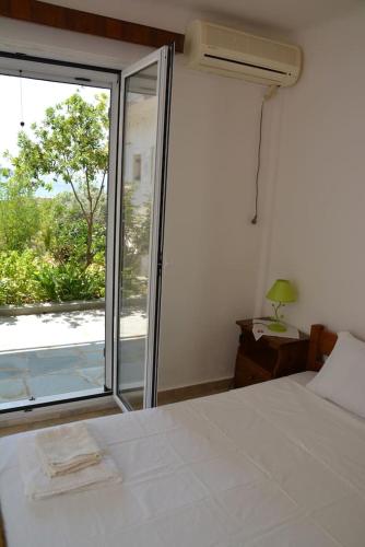 a bedroom with a bed and a sliding glass door at Traditional summer house in Marmari in Marmarion