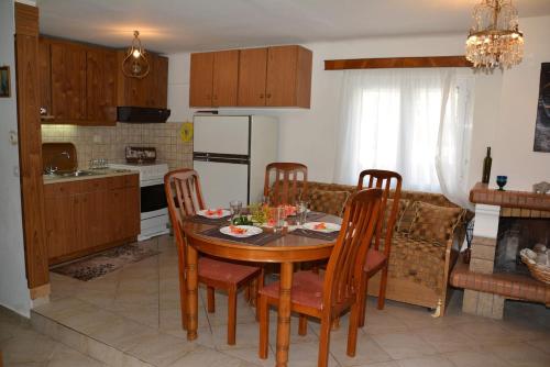 a kitchen with a table and chairs and a kitchen with a refrigerator at Traditional summer house in Marmari in Marmarion