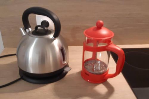 eine Teekanne und ein Wasserkocher auf dem Tisch in der Unterkunft CHE F3 gauche Terrasse jardin barbecue hypercentre wifi in Cherbourg en Cotentin