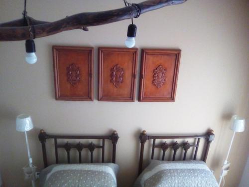 two beds on a wall with three pictures on the wall at Federicocasa in Alberobello