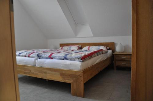 a bedroom with a wooden bed with a night stand at Ferienwohnung Kaplan in Bad Zwischenahn