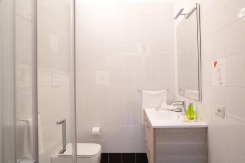 a white bathroom with a toilet and a shower at Fuori le Mura in Paestum