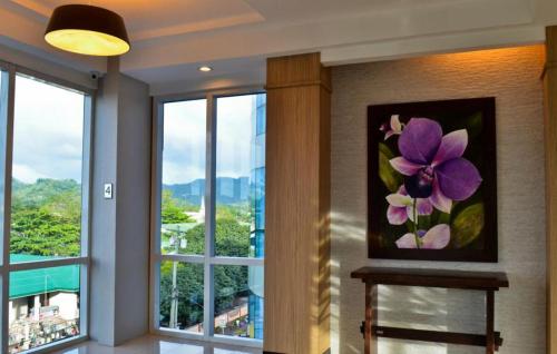 a painting of a purple flower on a wall with windows at D'Hotel & Suites in Dipolog
