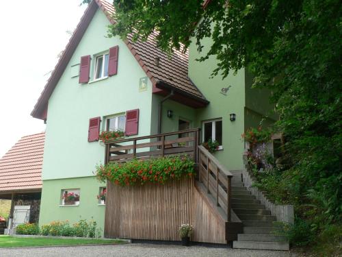 a house with stairs and flower boxes on it at Gite de la Lisière du Bois in Ueberstrass