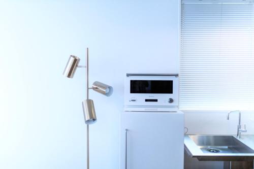a kitchen with a microwave on top of a refrigerator at THE ROOT2 HOTEL in Kyoto