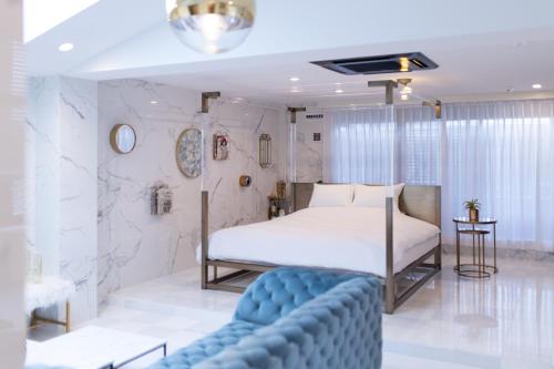 京都市にあるTHE ROOT2 HOTELのベッドルーム(ベッド1台、青いソファ付)