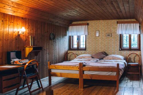 1 dormitorio con 1 cama y escritorio con ordenador en Hiša na Pohorju en Šmartno na Pohorju