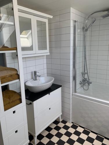 a white bathroom with a sink and a shower at Hem till Bengt in Kungshamn