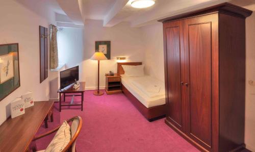 a hotel room with a bedroom with a bed and a desk at Gut Funkenhof in Sundern