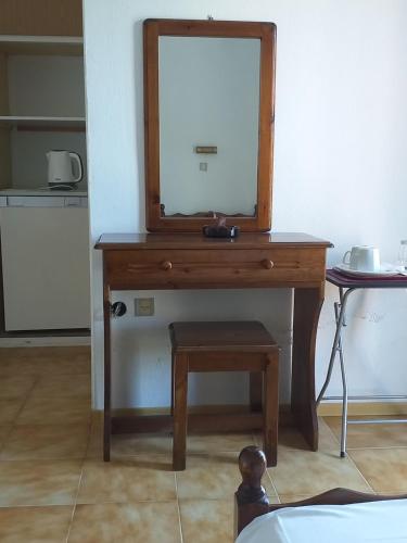 einen hölzernen Frisiertisch mit einem Spiegel darauf in der Unterkunft SAM΄S ROOMS in Korfu-Stadt