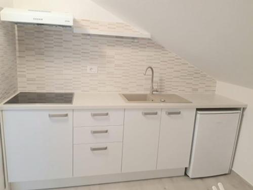 uma cozinha branca com um lavatório e um fogão em Apartments Marino em Senj