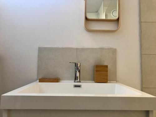 un lavabo blanc avec un miroir au mur dans l'établissement Grand T3 en duplex pour 6 avec parking couvert, à Cauterets