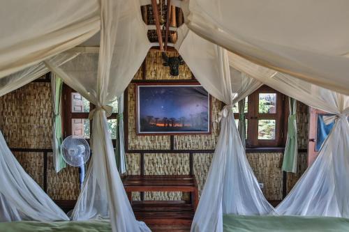 a bedroom with a bed with mosquito nets at KIMONY RESORT in Morondava