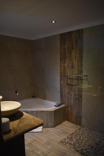 a bathroom with a tub and a sink at Waterfalls Boutique Hotel in Pretoria