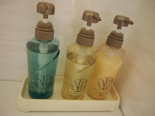 three bottles of detergents sitting in a holder at Hotel TAU, Kumamoto in Kumamoto