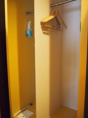 a bathroom with a shower with a yellow wall at Hotel TAU, Kumamoto in Kumamoto