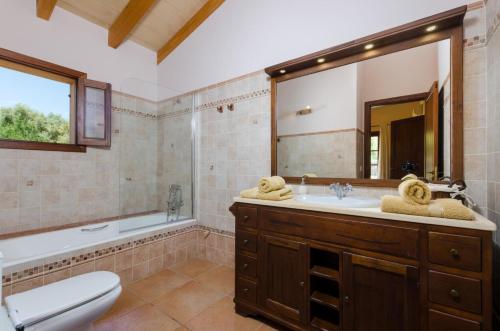 ein Badezimmer mit einem Waschbecken, einem WC und einem Spiegel in der Unterkunft Es Vedat 6 in Lloret de Vistalegre