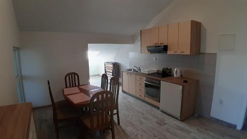une cuisine avec une petite table et des chaises ainsi qu'une cuisine avec une cuisinière dans l'établissement Relax, à Starigrad-Paklenica