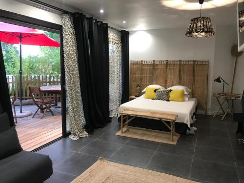 カシにあるVilla le sud appartementsのベッドルーム1室(ベッド1台付)、パティオ(テーブル付)