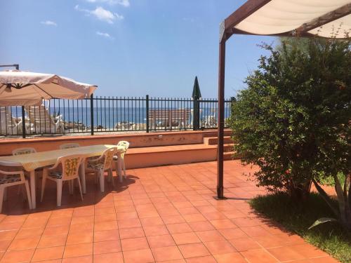 a patio with a table and chairs and an umbrella at Il terrazzino di Lulù in Cetraro