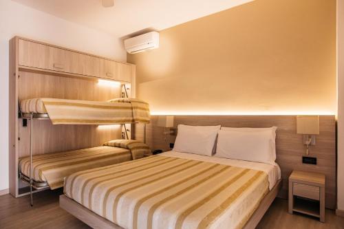 a hotel room with a bed and bunk beds at Hotel Angelo in Caorle