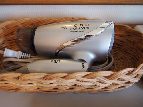 a basket with a hair dryer and a hair brush at Hotel TAU, Kumamoto in Kumamoto