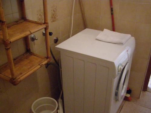 a small white refrigerator in a kitchen with a shelf at House Kaić in Selce