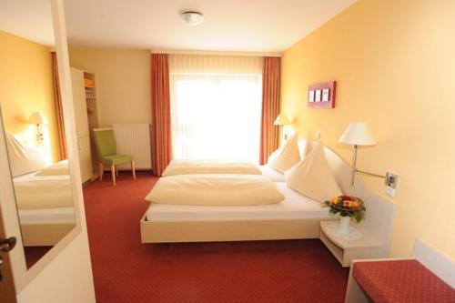 a hotel room with two beds and a window at Hotel Reischenau in Ustersbach