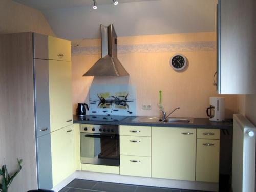 a kitchen with white cabinets and a stove top oven at Ferienwohnung Haus Andre _ fuer 4 in Ulmen