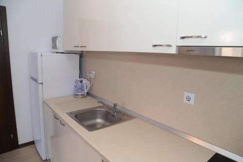 a small kitchen with a sink and a refrigerator at Морски Бряг in Sveti Vlas