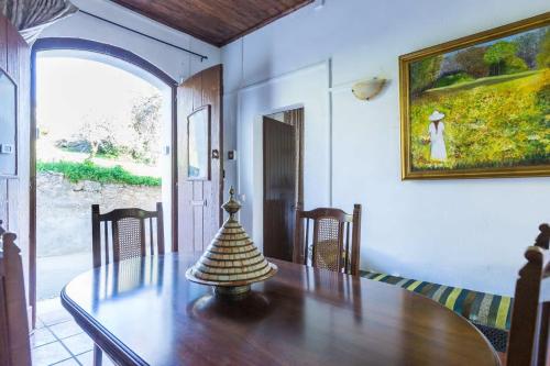 a dining room with a table and a painting on the wall at Solar da Rosa & Solar da Tirosa in Boliqueime