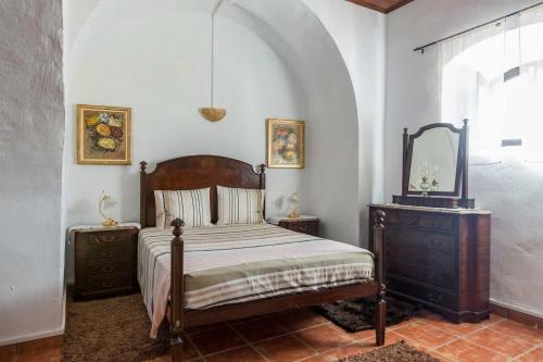 a bedroom with a bed and a dresser and a mirror at Solar da Rosa & Solar da Tirosa in Boliqueime