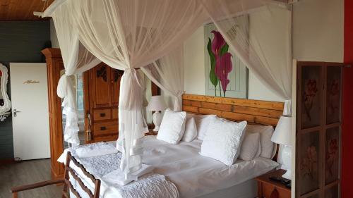 a bedroom with a white bed with a canopy at The-Ark B&B in Pearly Beach