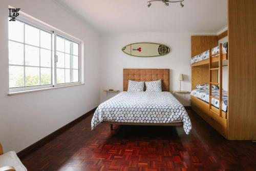 a bedroom with a bed and two windows at NVidas in Figueira da Foz