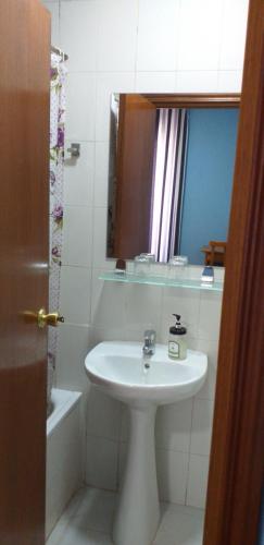 a bathroom with a sink and a mirror at Hostal Río Paraná in Madrid