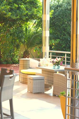 a patio with a couch and a table and chairs at SelaMod Village Guest House in Tshaneng