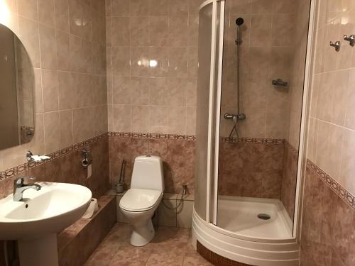 a bathroom with a toilet and a shower and a sink at Safari Hotel Complex in Samara